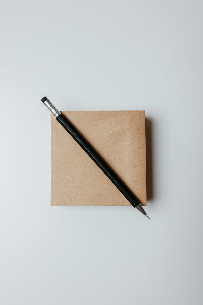 Lápiz sobre una libreta de papel kraft sobre un fondo claro